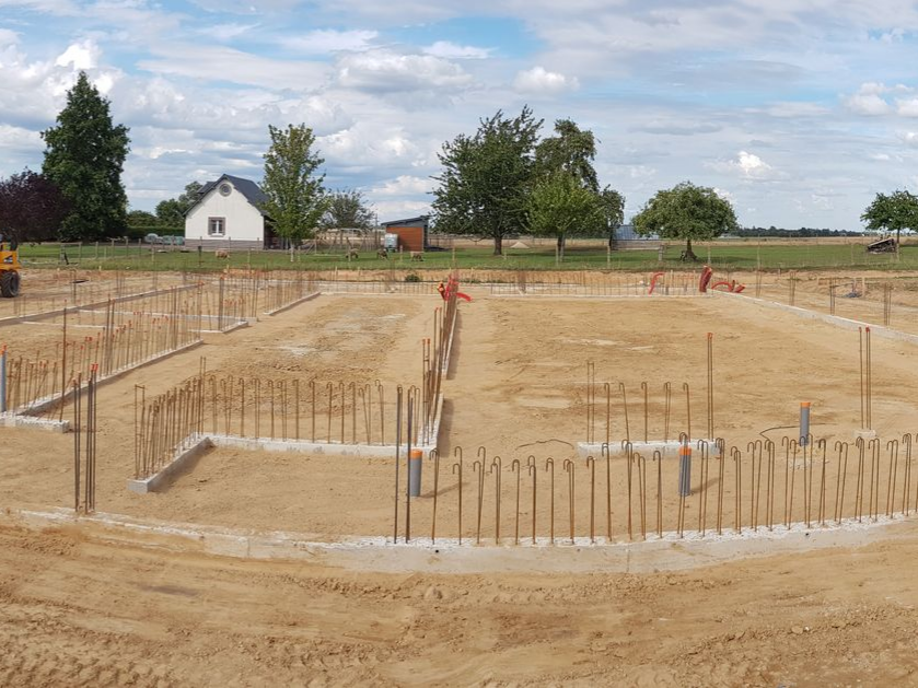 Fondations préparées pour une future construction - maison et champ en fond