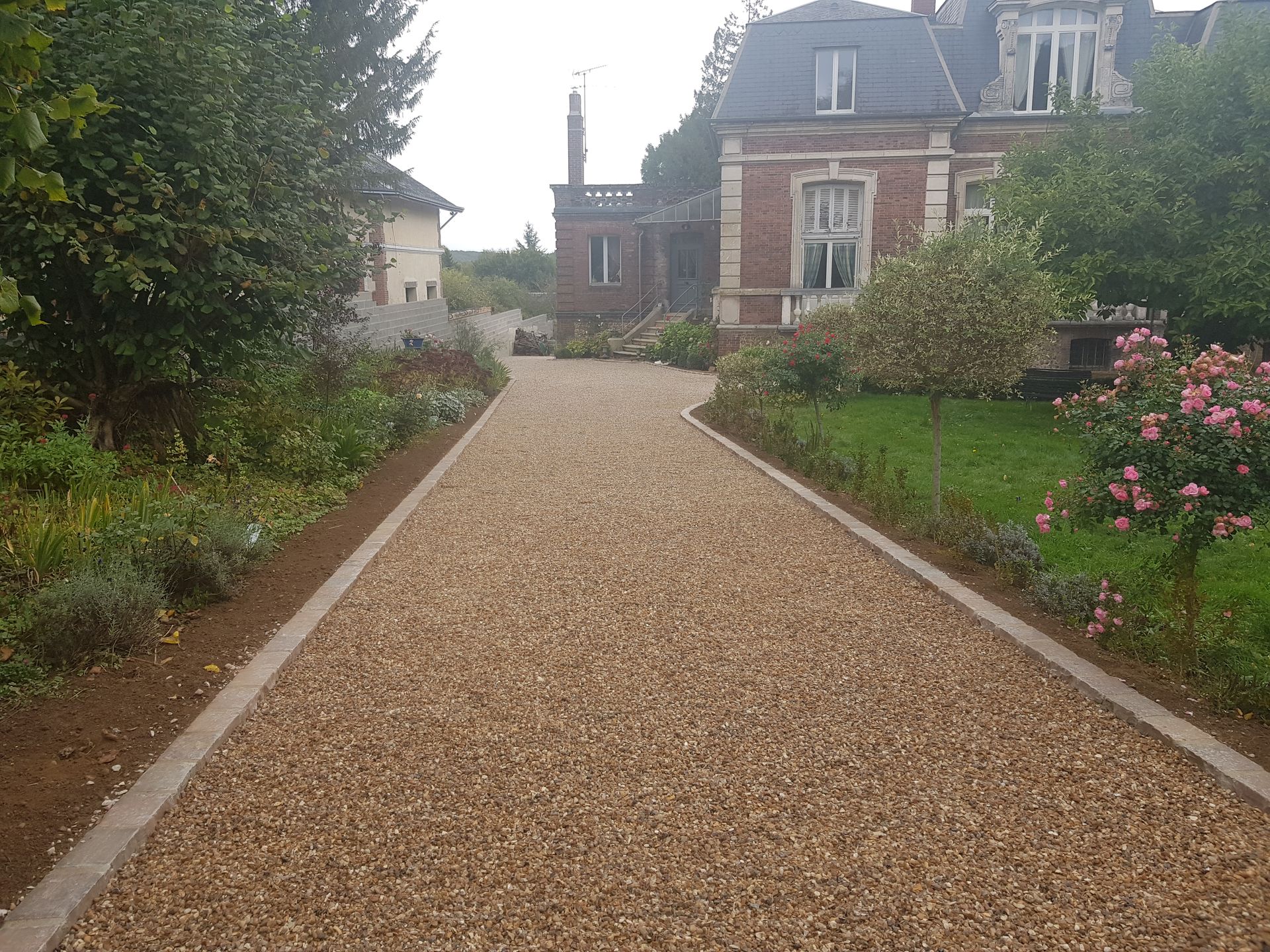 Grande allée en gravier qui mène à un manoir