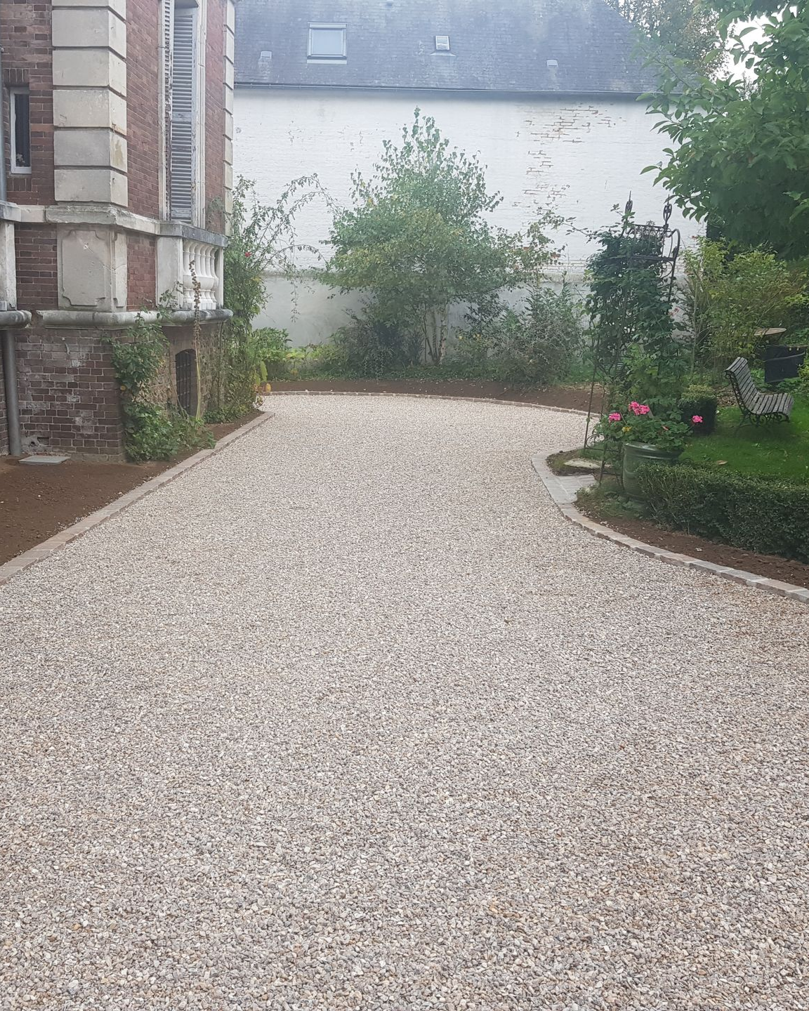 Création d'une allée en gravier et d'une bordure dans le jardin d'une maison