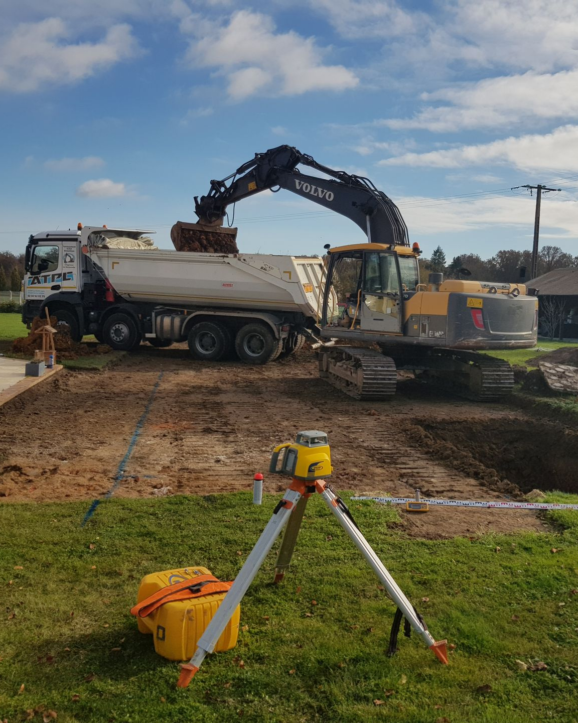 Minipelle qui remplit de terre un camion-benne