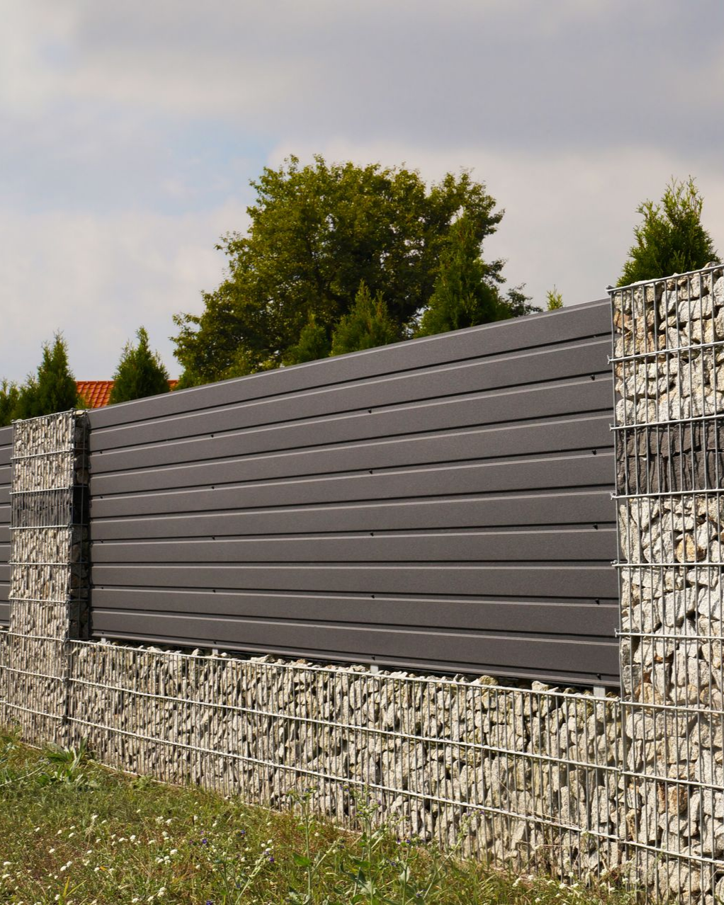 Clôture anthracite avec des poteaux grillagés remplis de cailloux