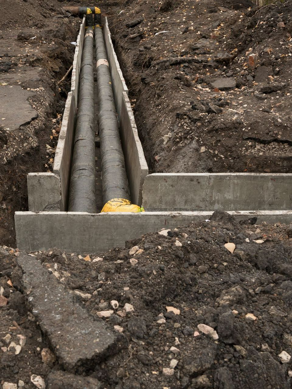 Installation de 2 tuyaux de VRD et de protection en béton autour