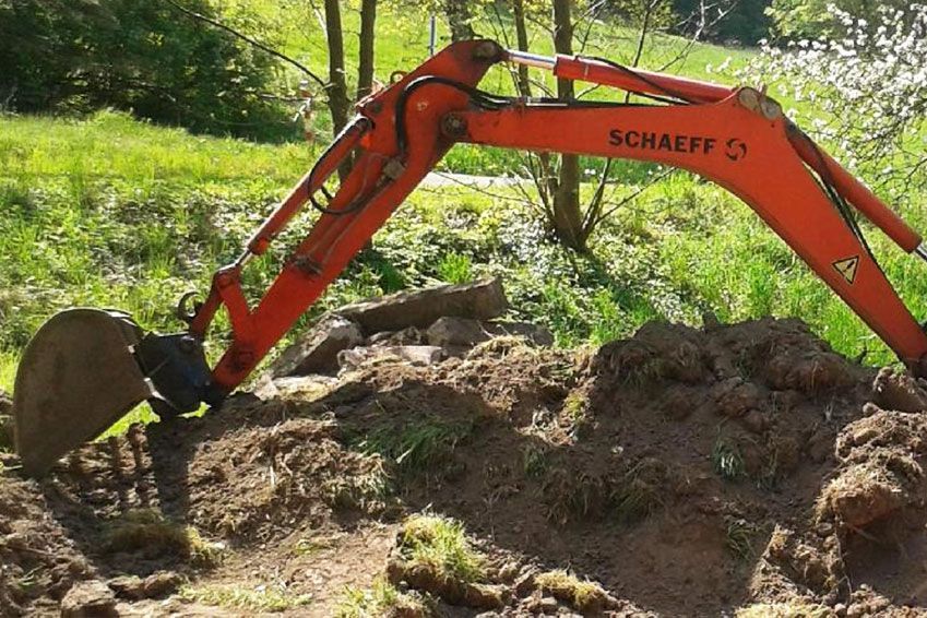 Ein Schaeff-Bagger gräbt ein Loch in den Dreck