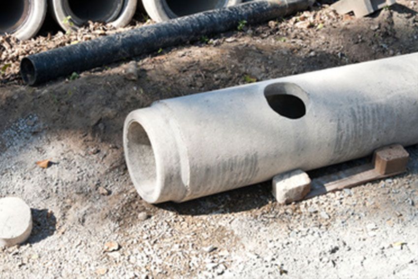 Auf dem Boden liegt ein Betonrohr mit einem Loch in der Mitte.