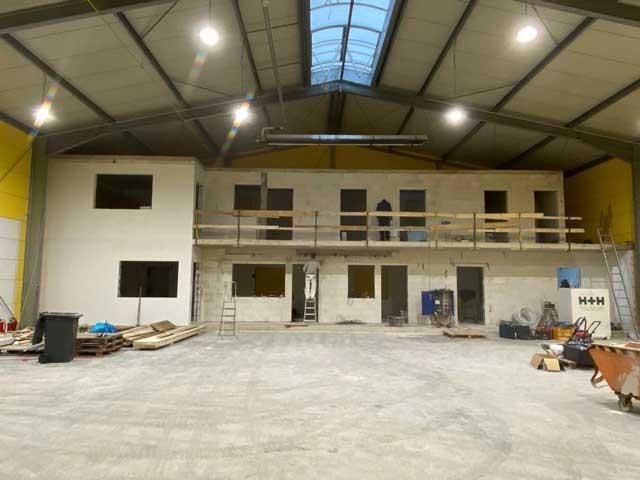 Ein großes im Bau befindliches Gebäude mit einem Dach, das über ein Oberlicht verfügt