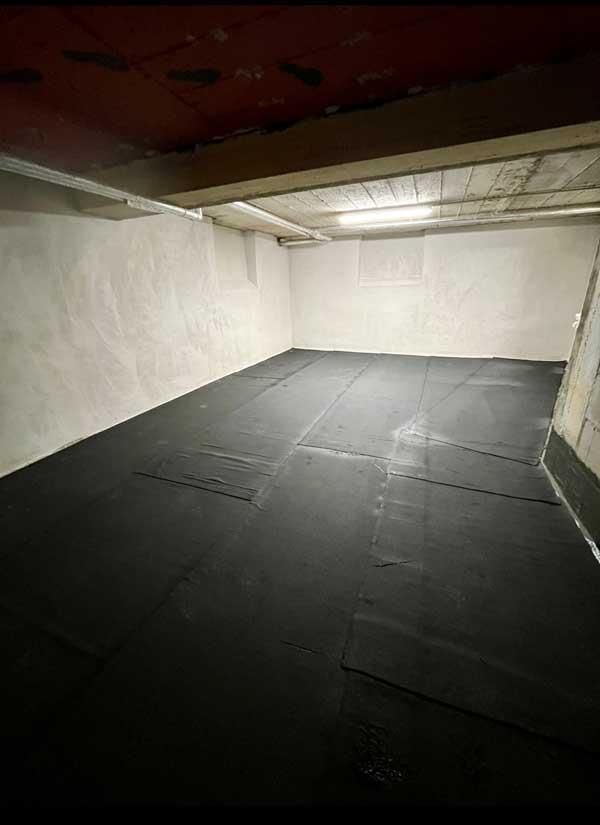 Ein großer leerer Raum mit einer schwarzen Matte auf dem Boden.