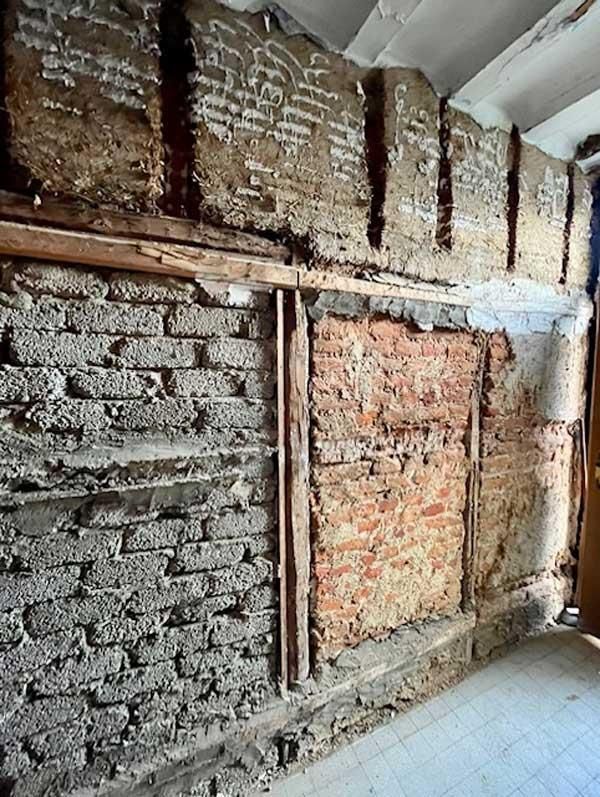 Eine Backsteinmauer, auf der Heuballen gestapelt sind.