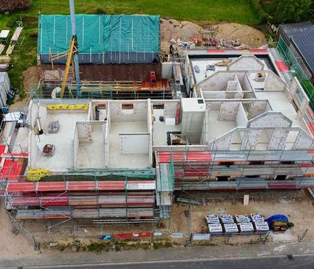 Eine Luftaufnahme eines im Bau befindlichen Gebäudes mit Gerüst und Kran.