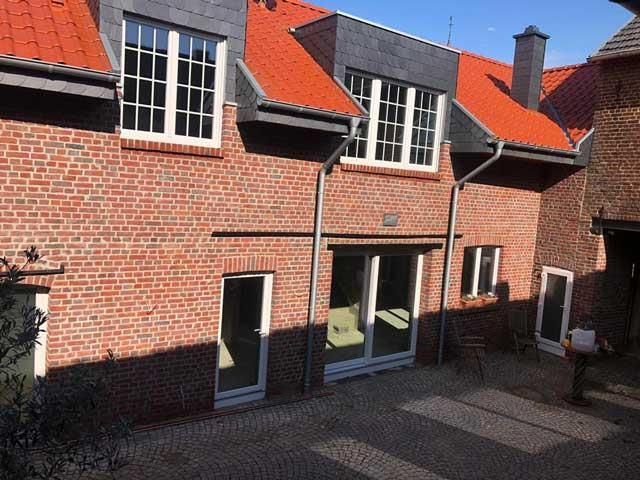 Ein Backsteingebäude mit rotem Dach und weißen Fenstern