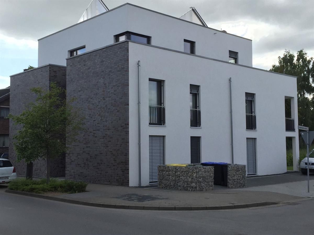 Ein Gebäude mit vielen Fenstern und einem Mülleimer davor