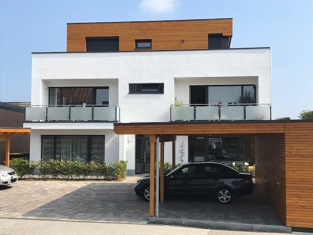 Ein Auto ist unter einem Carport vor einem Haus geparkt.