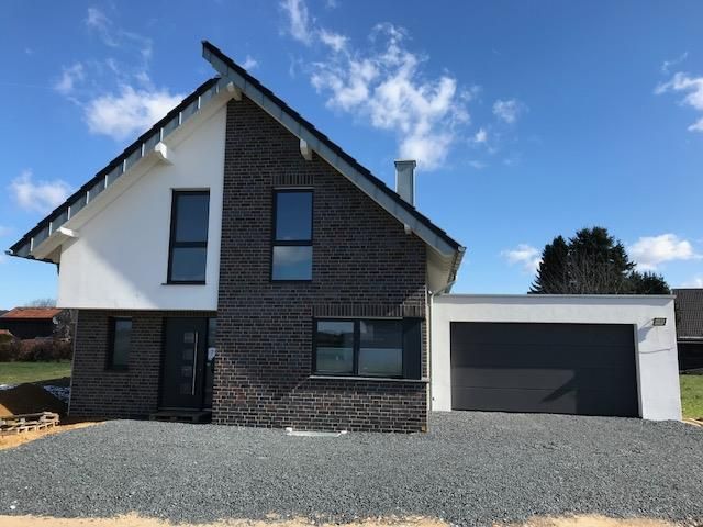 Ein Backsteinhaus mit einer Garage darunter