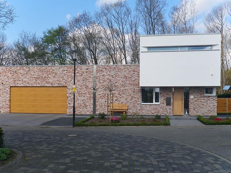 Ein Backsteinhaus mit einem hölzernen Garagentor
