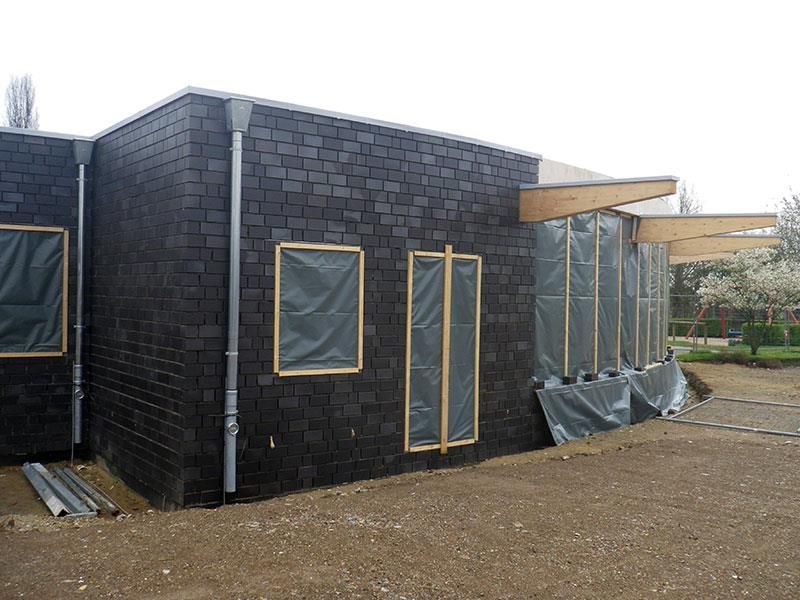 Ein schwarzes Backsteingebäude mit vielen Fenstern