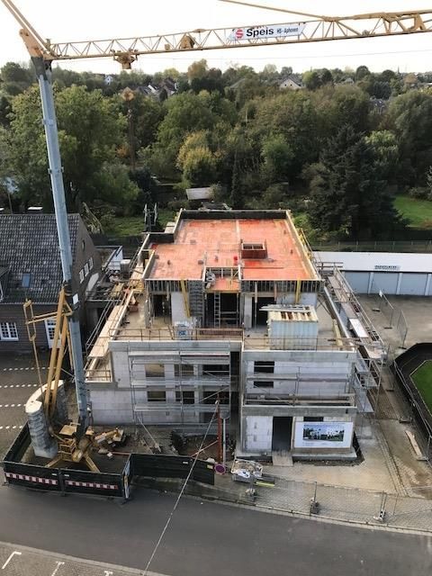 Eine Luftaufnahme eines im Bau befindlichen Gebäudes mit einem Kran im Vordergrund.