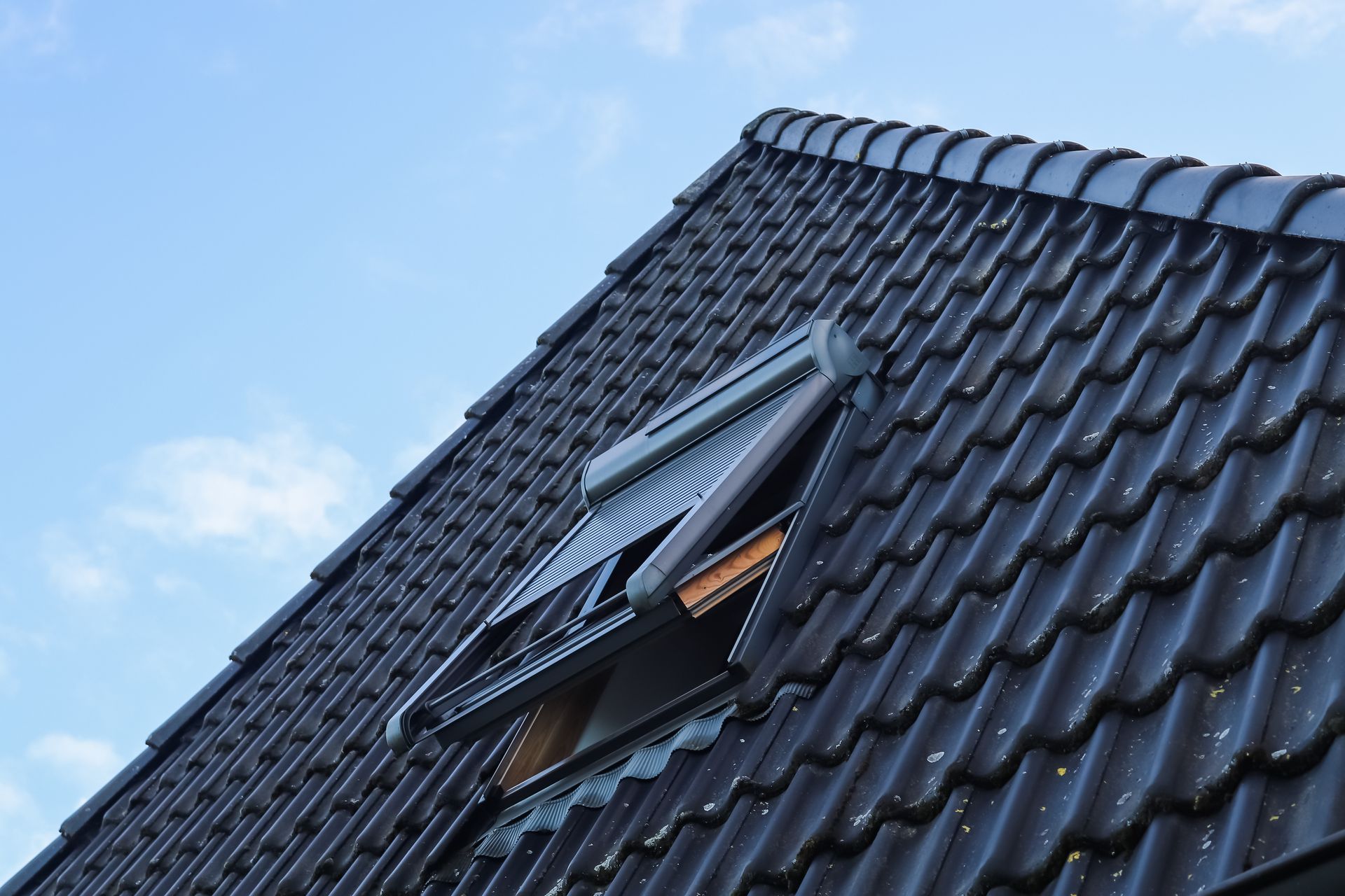 Un Velux ouvert sur un toit noir