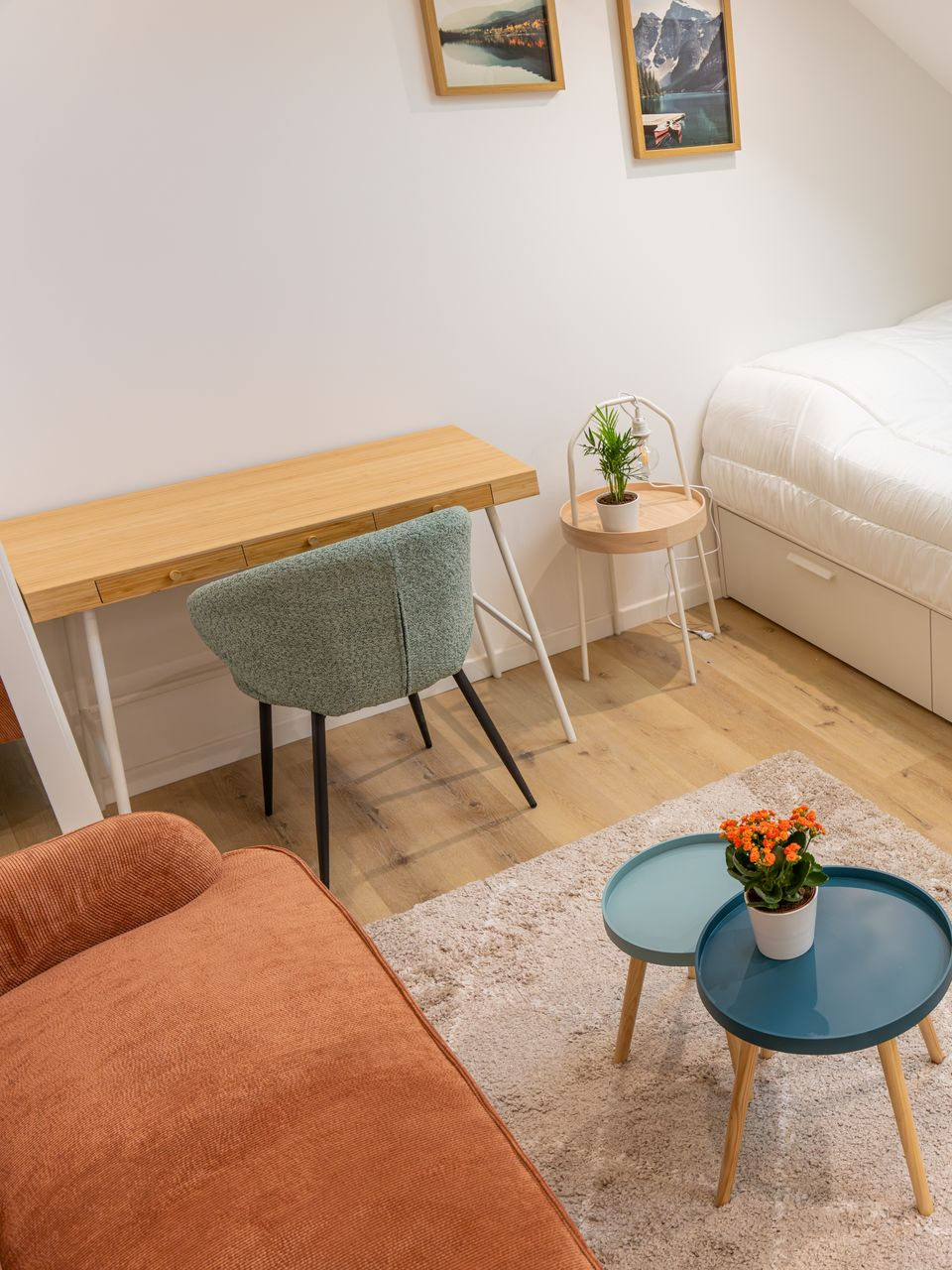 Chambre avec un bureau, une chaise, un lit et des tables de chevet, ainsi qu'un canapé et un tapis.