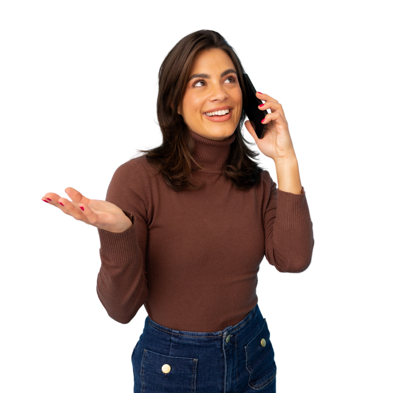 Femme en col roulé marron, parlant au téléphone avec un smartphone, faisant un geste de la main gauche, souriante.