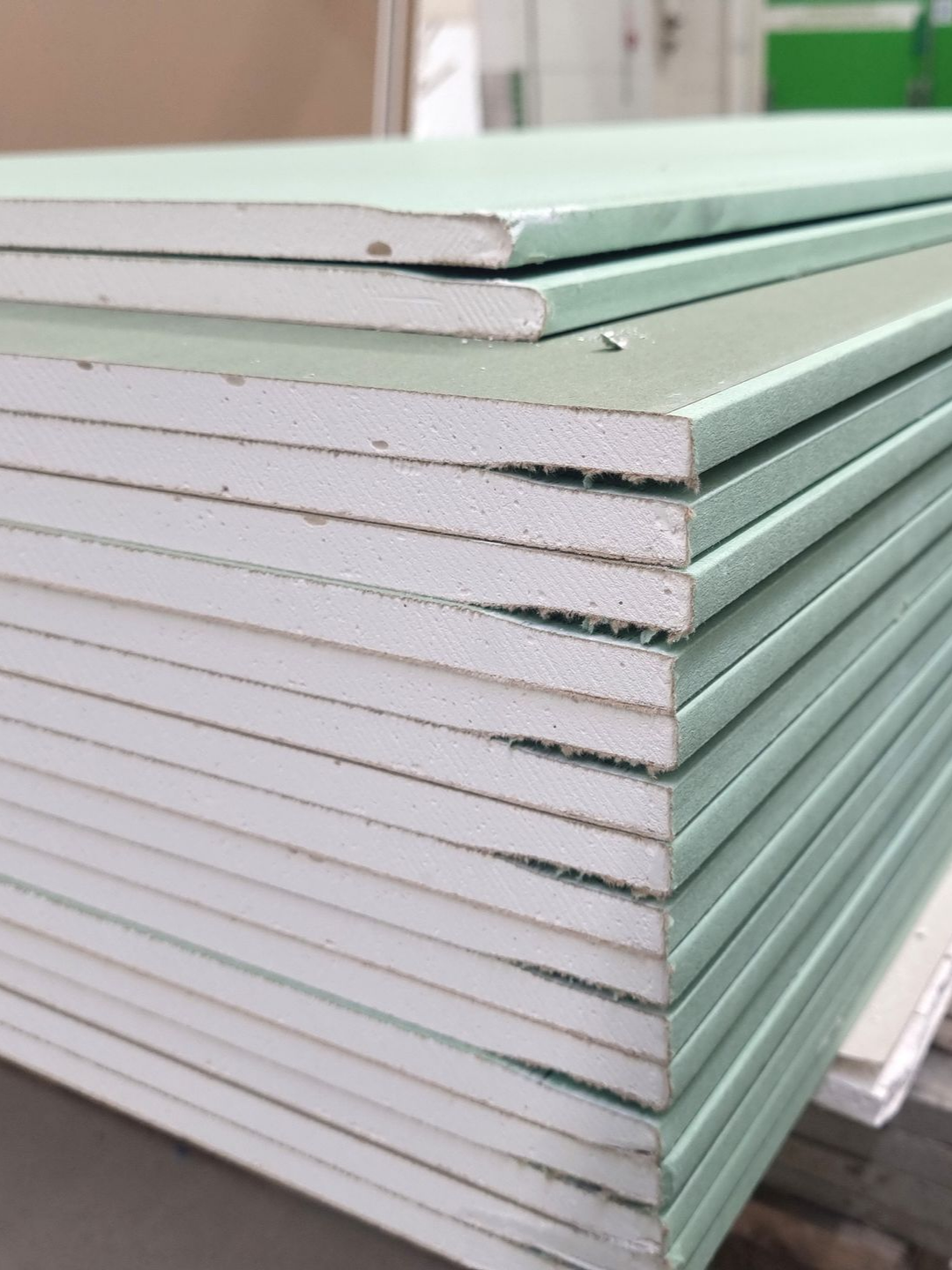 Pile de plaques de plâtre vertes.