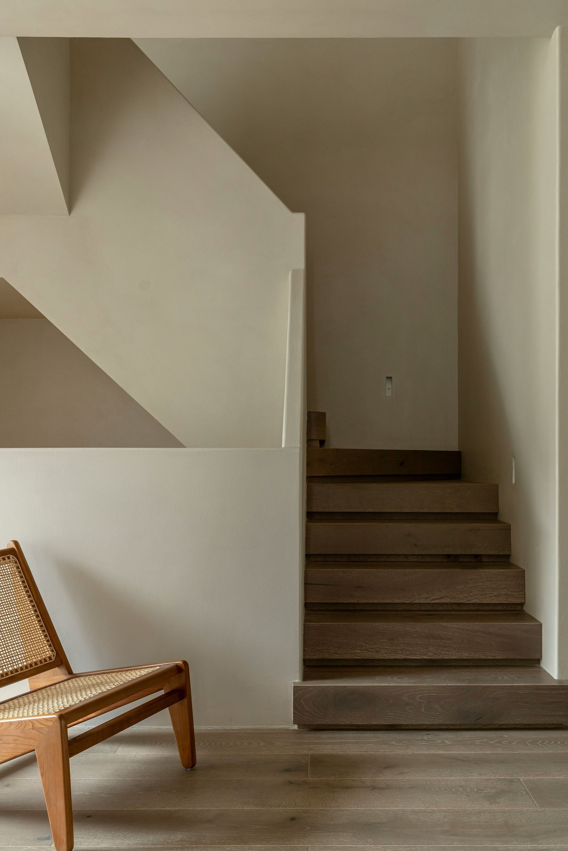 Una silla está junto a un conjunto de escaleras en una habitación.