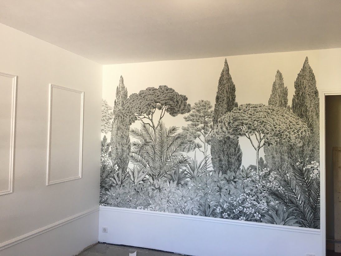 Chambre blanche avec une grande fresque murale en noir et blanc représentant une forêt sur un mur.