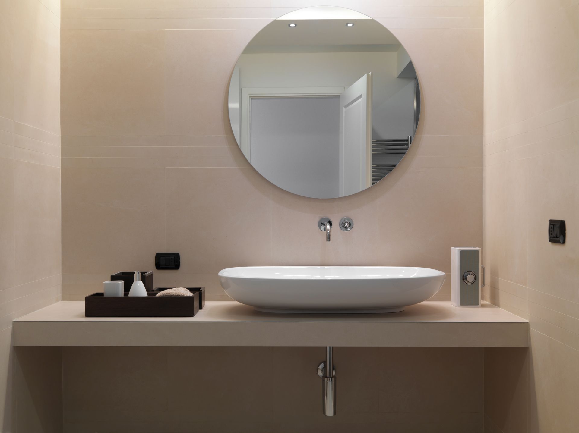 Salle de bains moderne avec baignoire îlot, douche à l'italienne et meuble-lavabo dans des tons gris sous puits de lumière