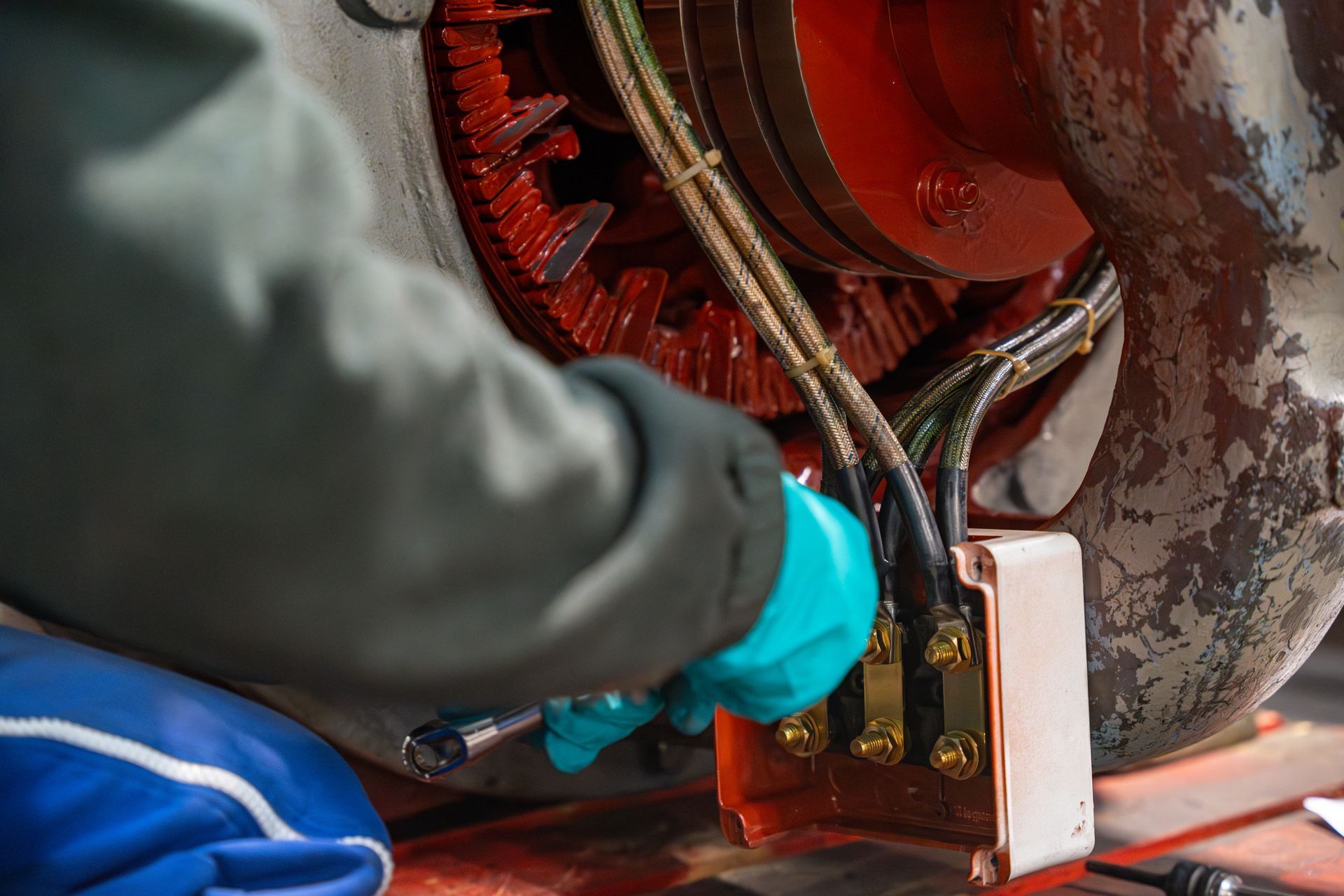 Un homme avec des gants intervient sur un moteur