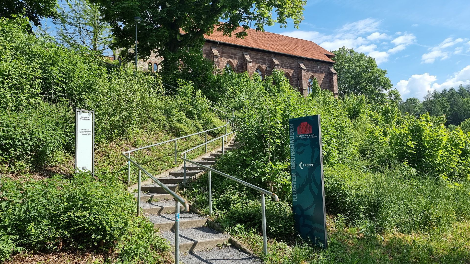 Im Hintergrund führt eine Treppe zu einem Gebäude hinauf.