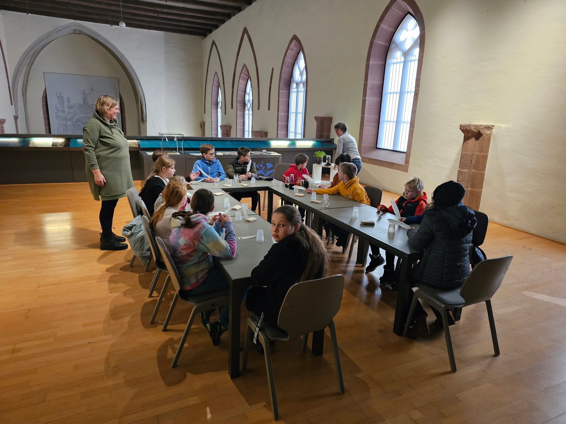 Eine Gruppe von Menschen sitzt in einem Raum an Tischen.