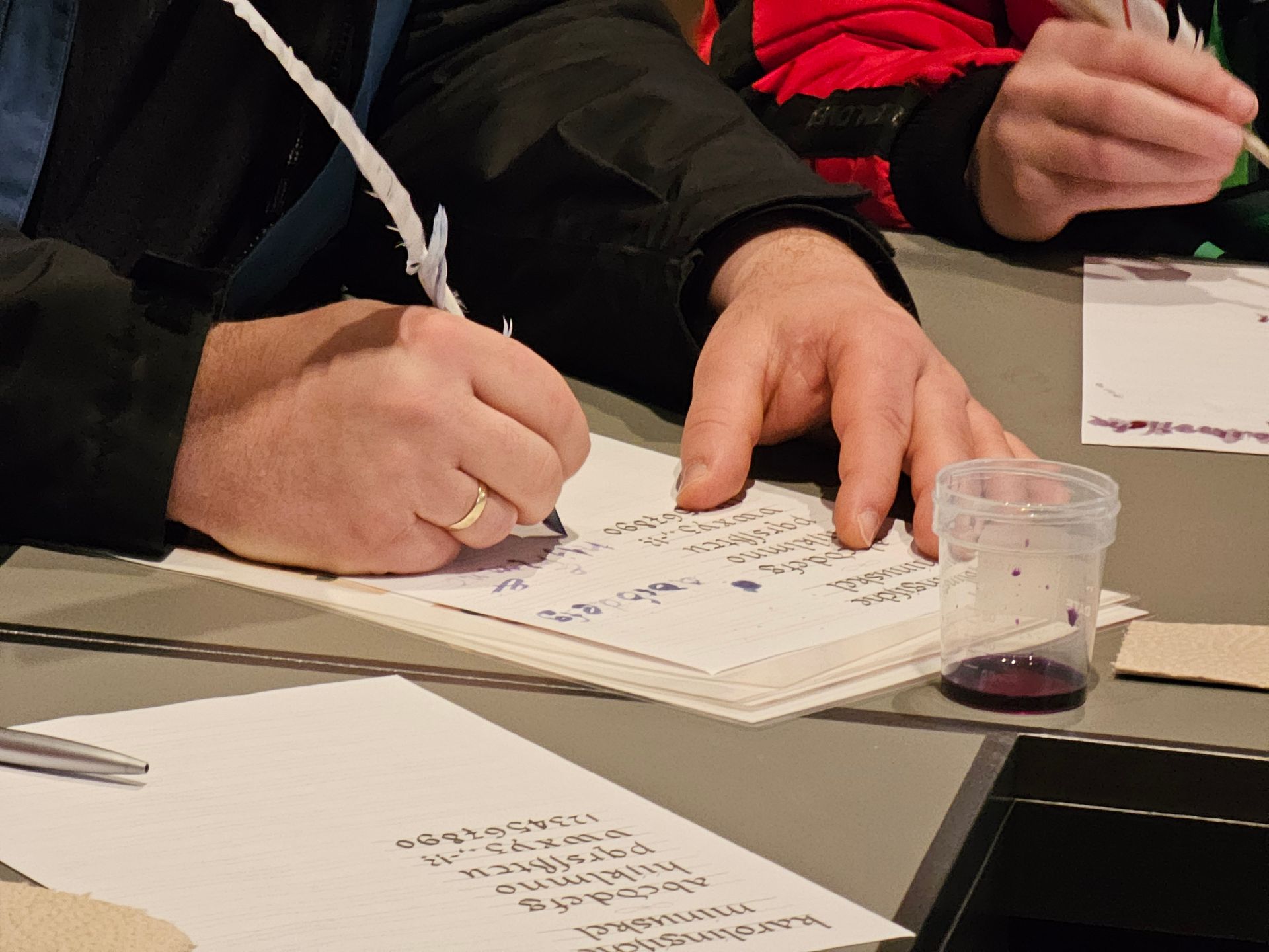 Ein Mann schreibt mit einer Feder auf ein Stück Papier