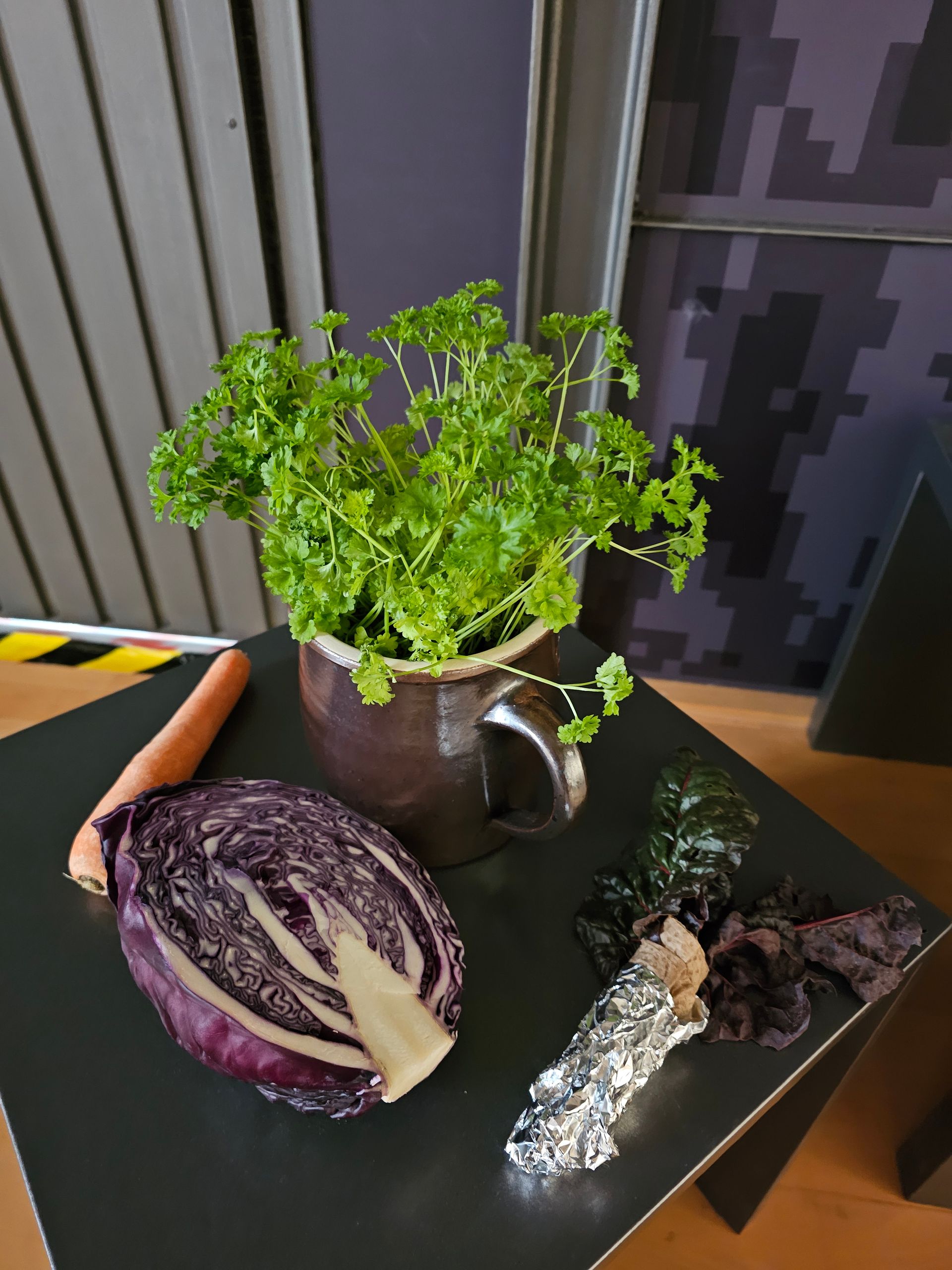 Ein Tisch mit Gemüse und einer Topfpflanze darauf