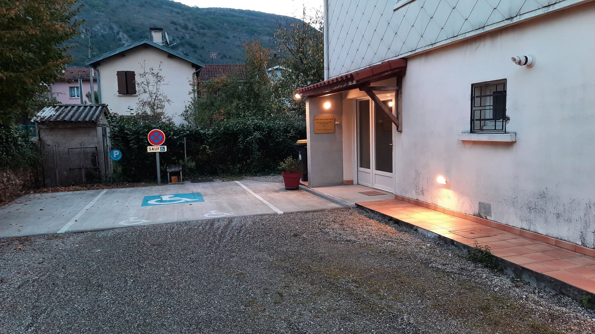 Salle d'attente avec chaises, petite table, œuvres d'art et vue extérieure.