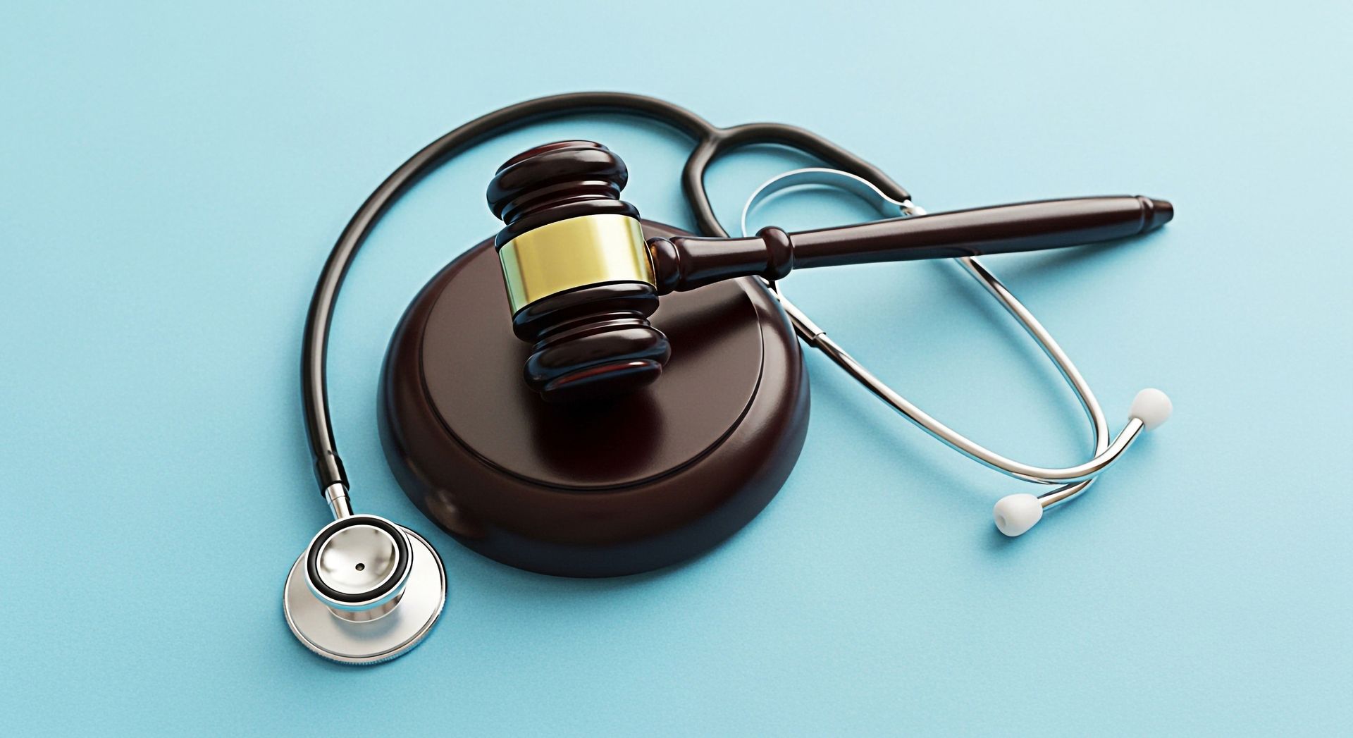 Maillet sur bloc de bois et stéthoscope sur fond bleu, symbolisant le droit médical.