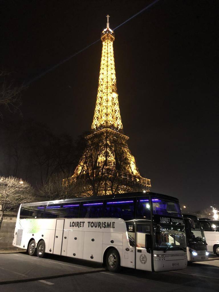 Bus devant la tour Eiffel de nuit