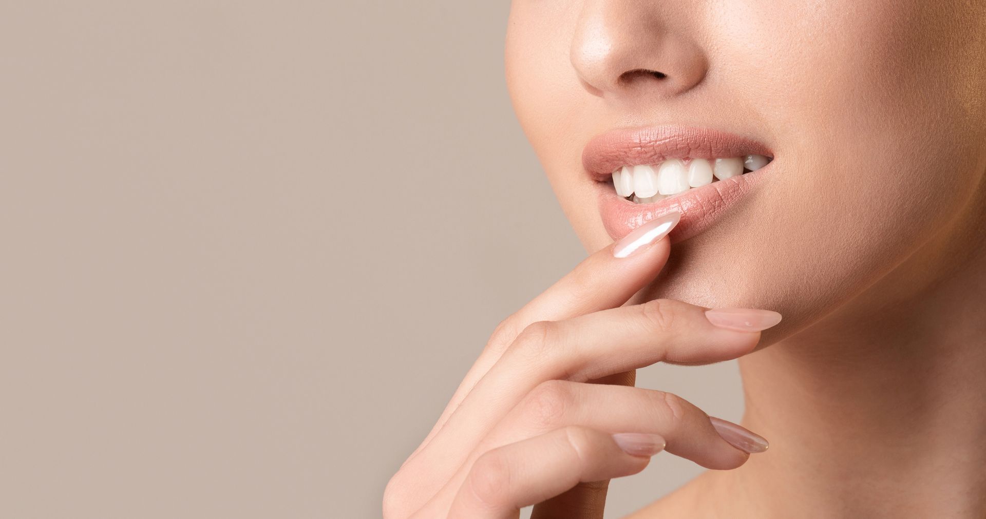 Eine Maniküristin trägt im Salon mit einem kleinen Pinsel roten Nagellack auf den Fingernagel einer Kundin auf.