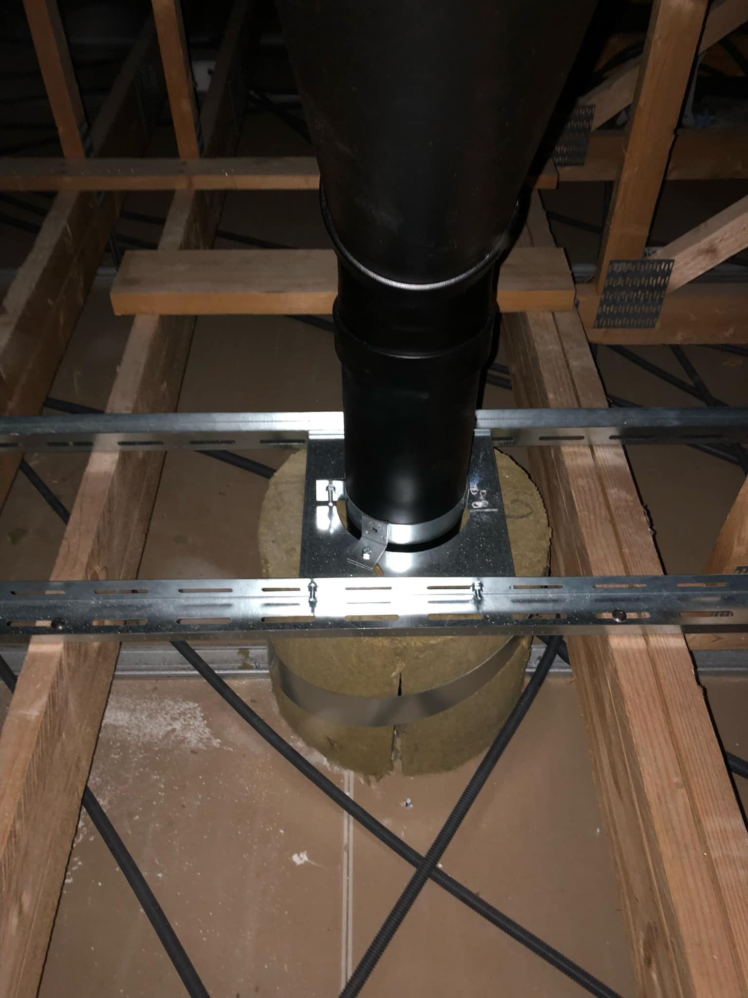 Passage d'un tubage de poêle dans les combles