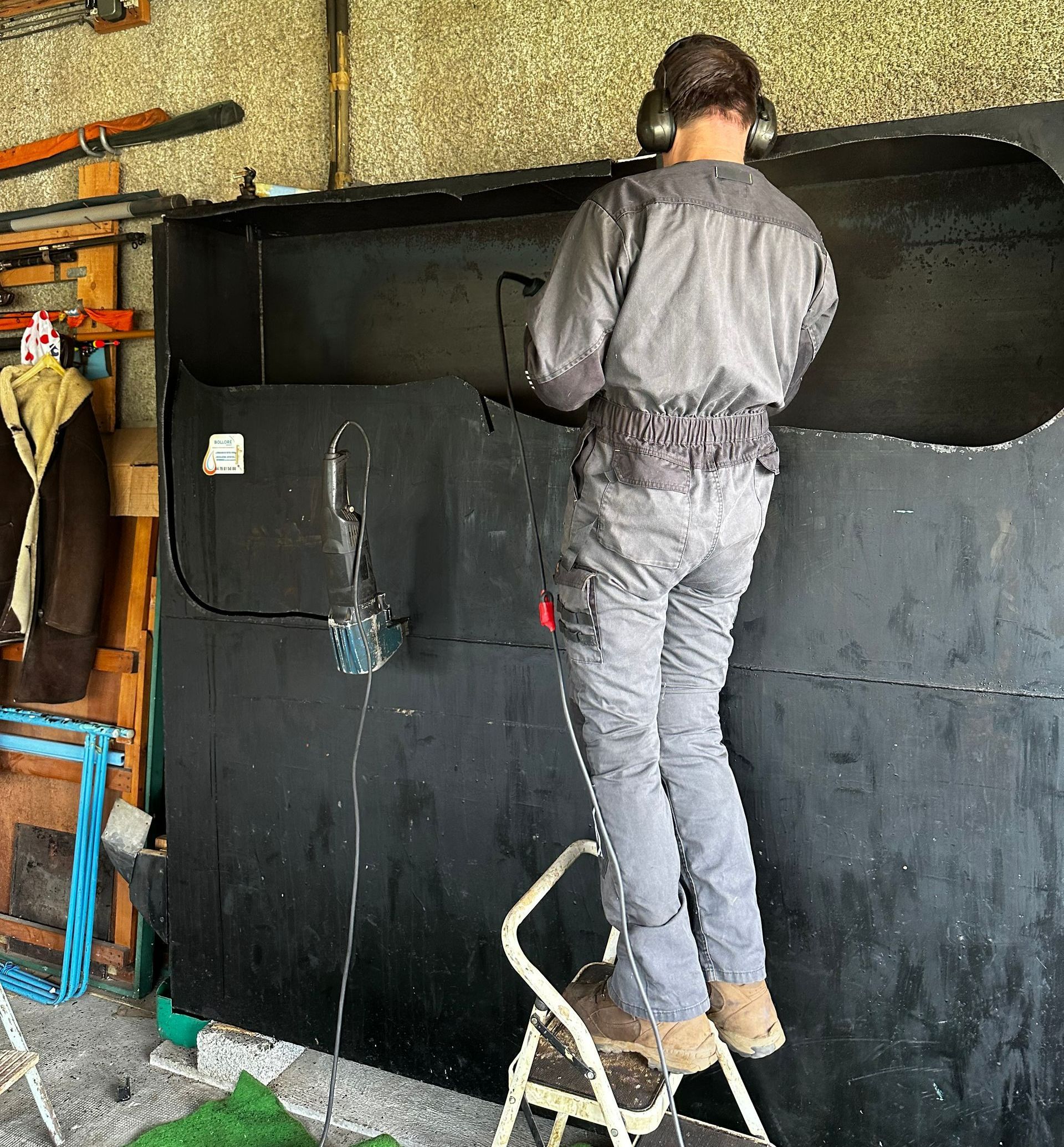 Professionnel de PROCUVE découpant une cuve en tenue de protection