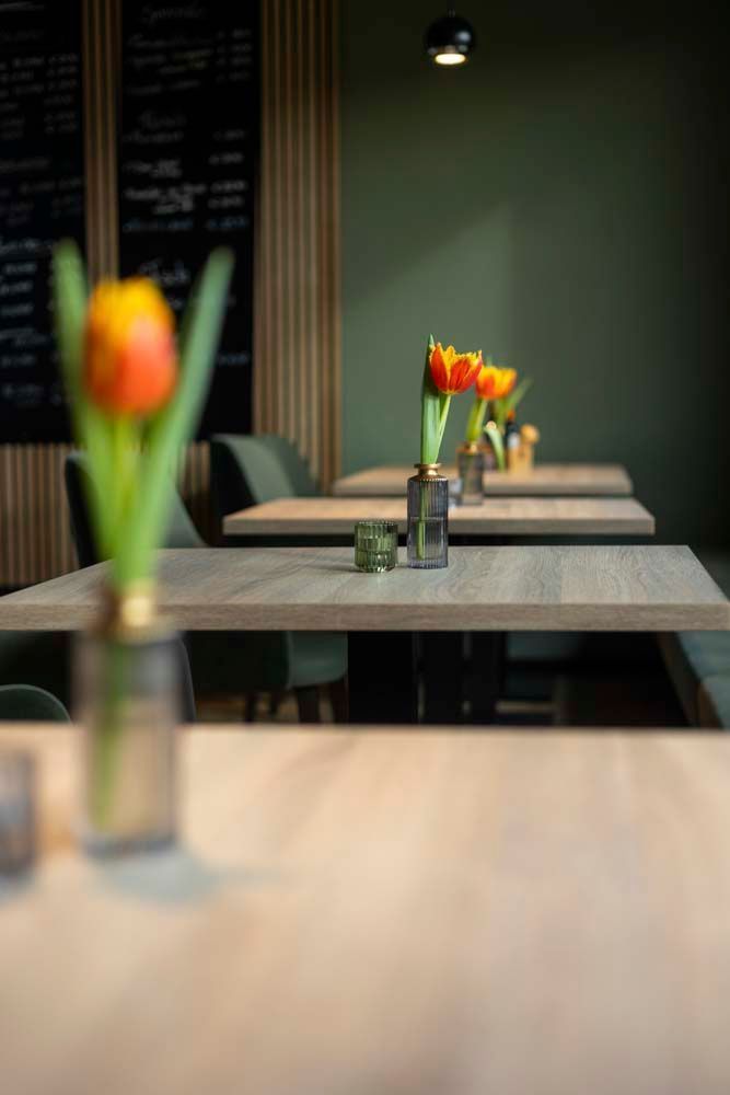 Eine Vase mit Blumen steht auf einem Tisch in einem Restaurant.