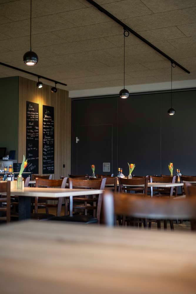 Ein Restaurant mit Tischen und Stühlen und einer Kreidetafel an der Wand.