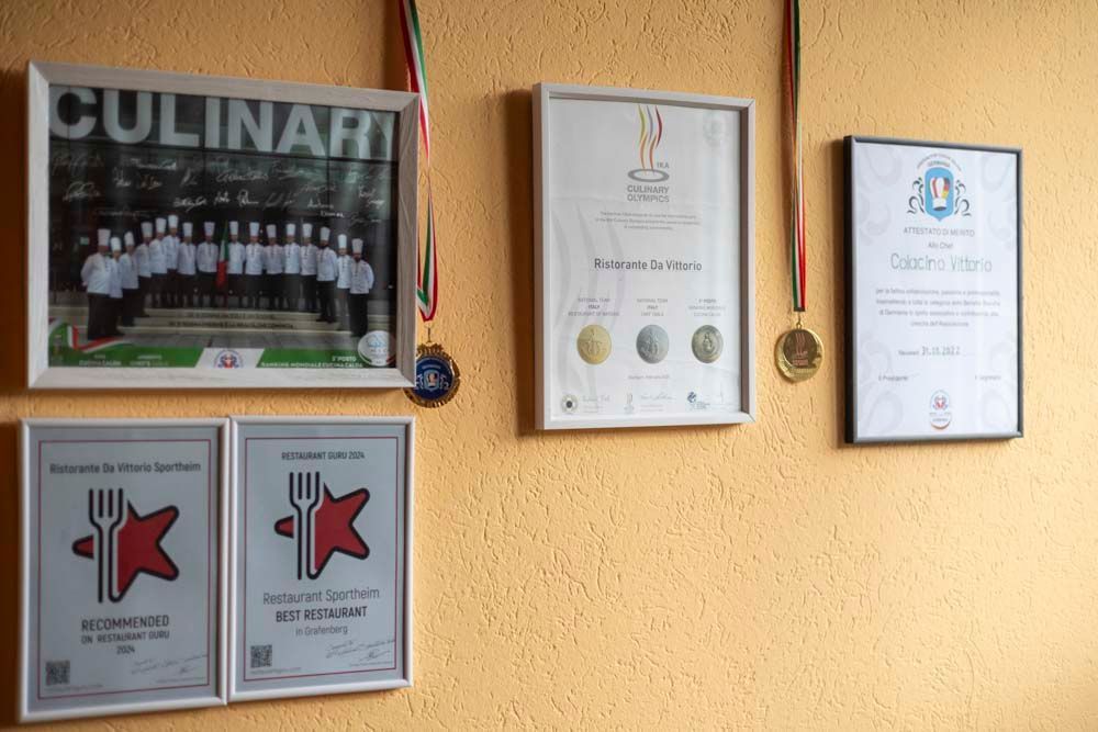 Eine Wand mit einem Haufen Zertifikate und Medaillen daran