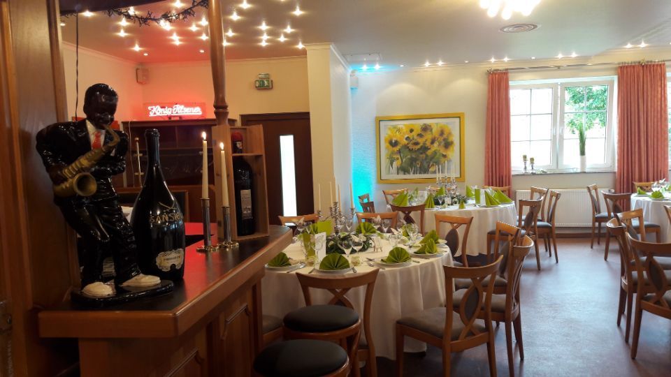 dekorierter Festsaal mit runden Tischen mit frühlingshafter Dekoration