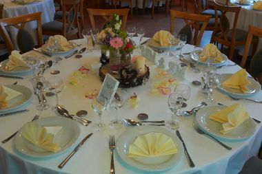 Gedeckter Tisch mit gelben Servietten und Kerzen