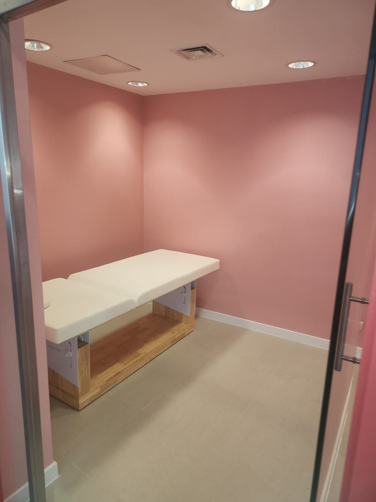 Una habitación con paredes rosas y una mesa blanca.