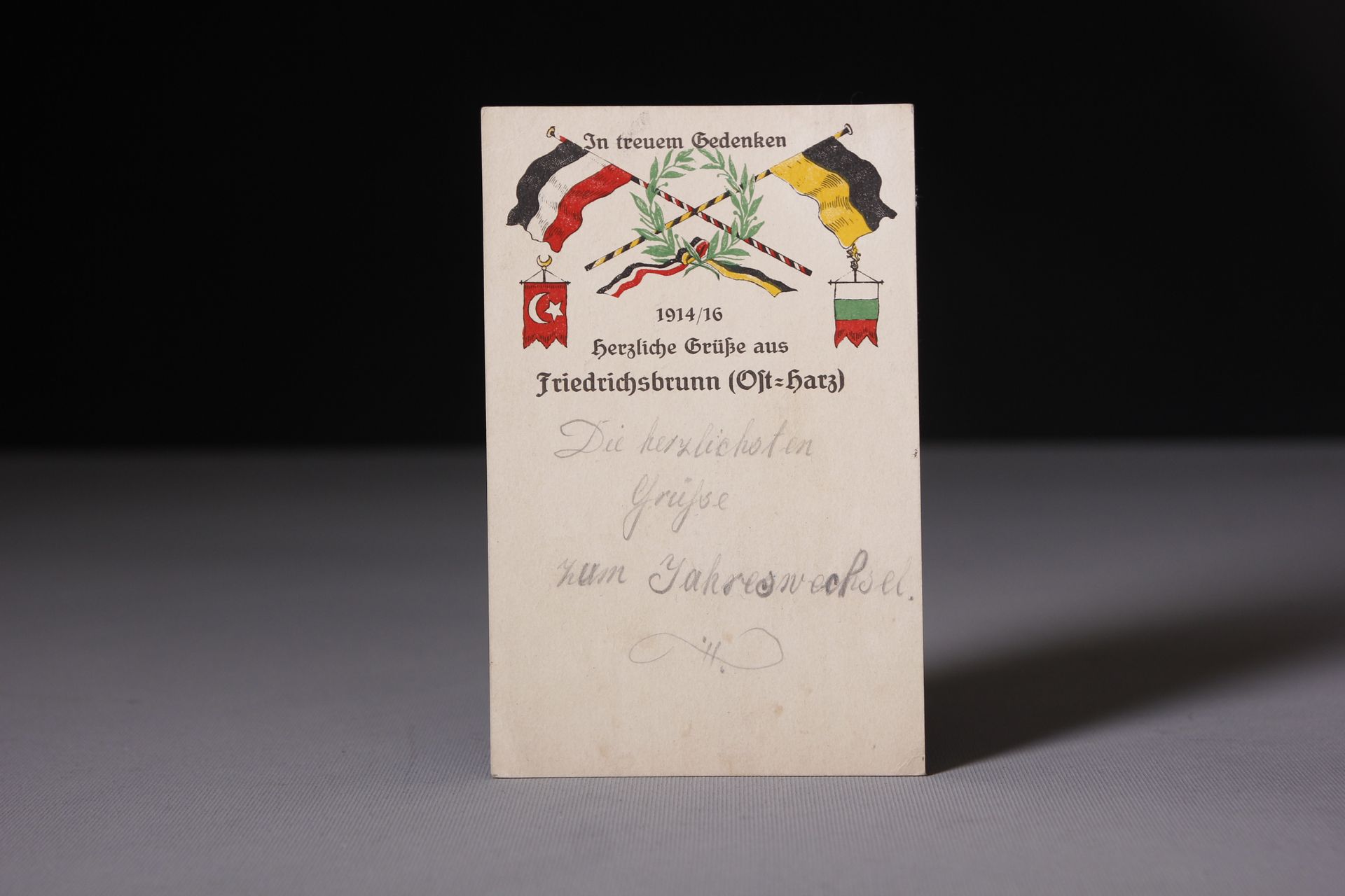 Antike Grußkarte oder Dokument mit historischer Beflaggung und Wappen.