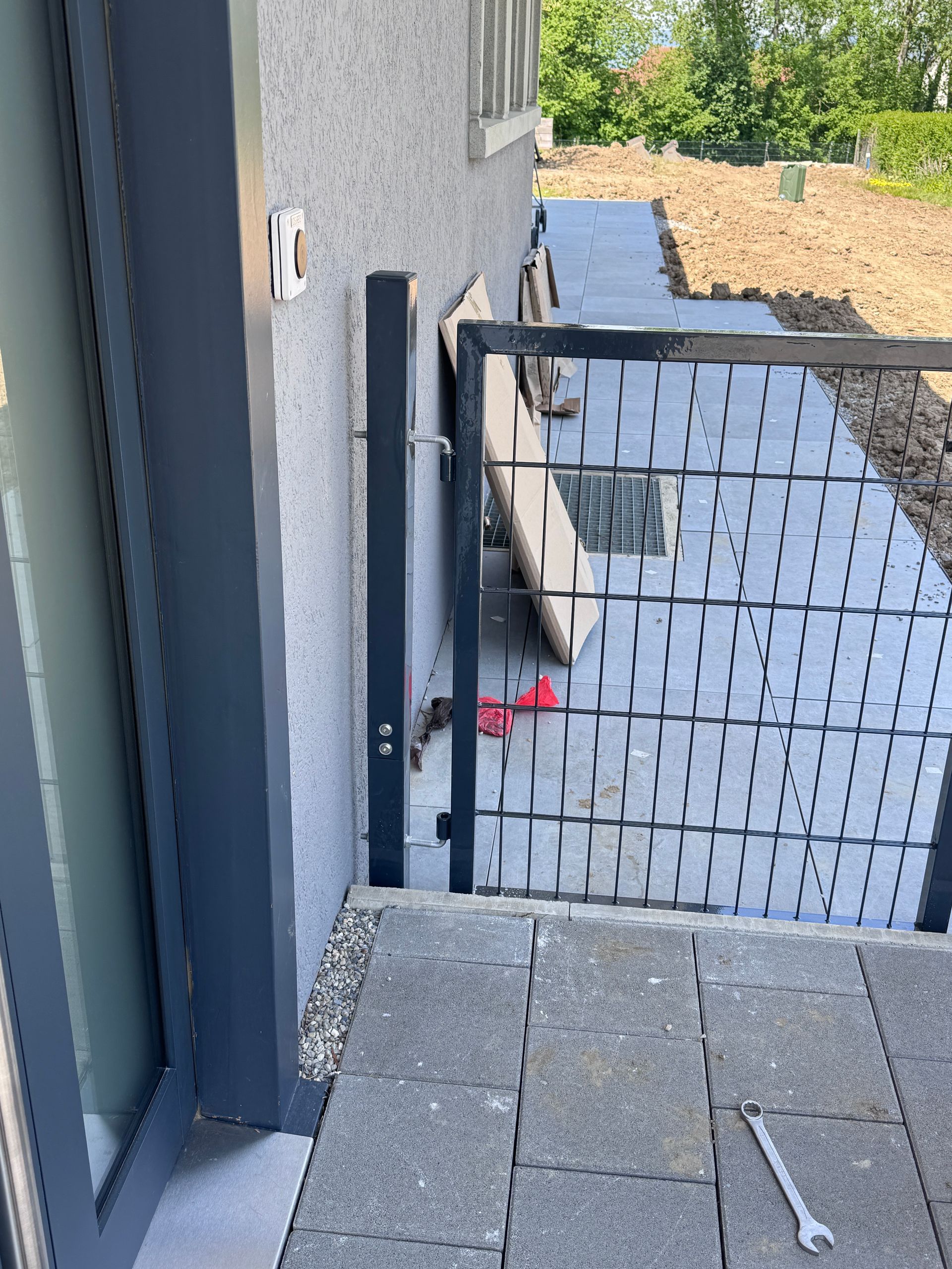Portillon métallique installé près de l’entrée d’une maison