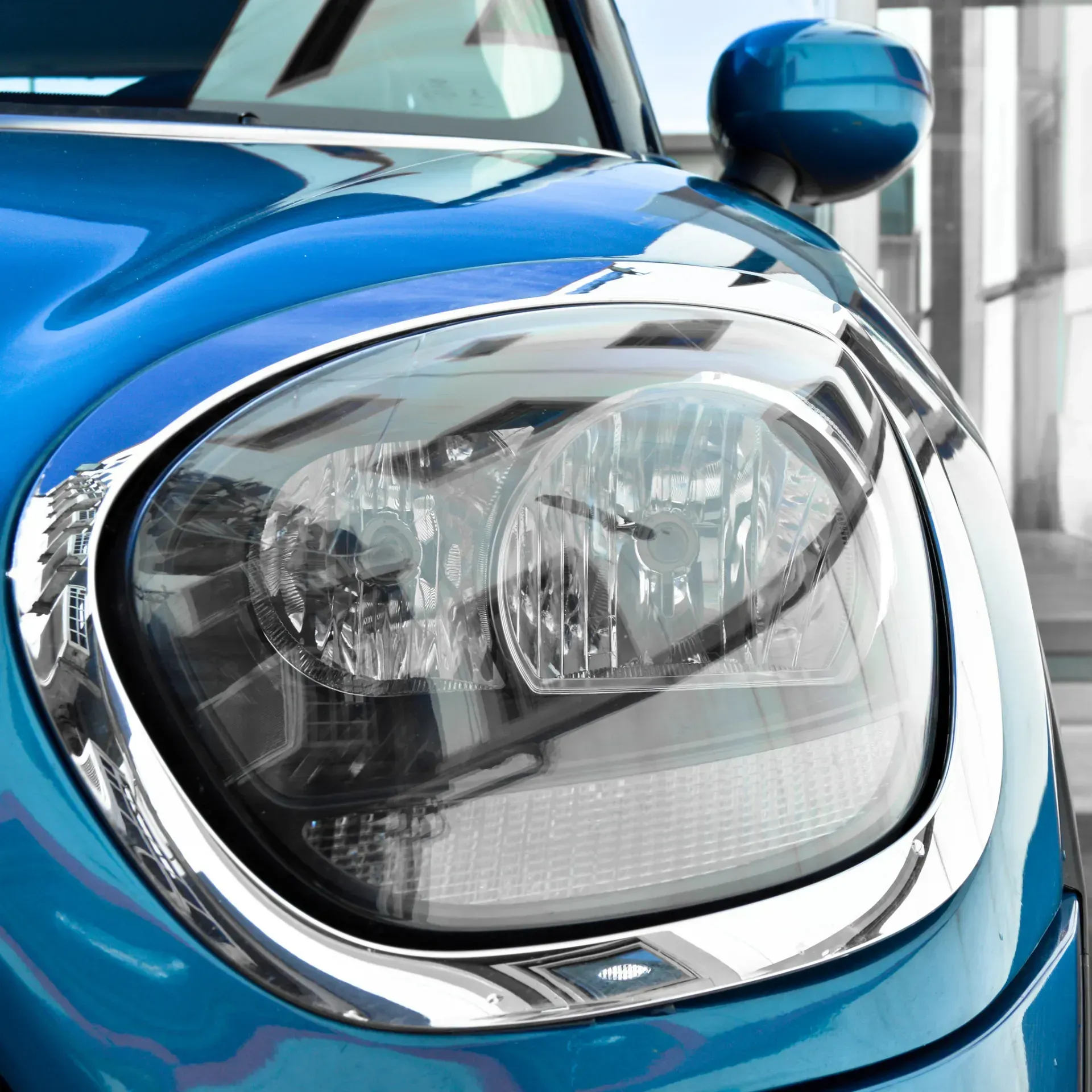 Un primer plano del faro de un coche azul.