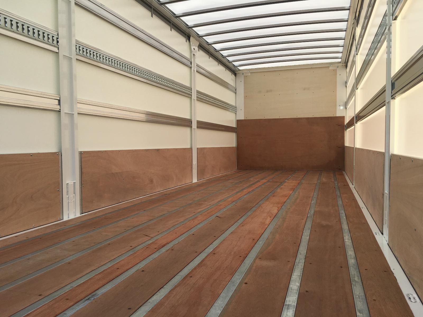 Plancher bois dur avec protection bois sur intérieur de ridelle et face Av planche de rehausse avec rail d'arrimage intégré