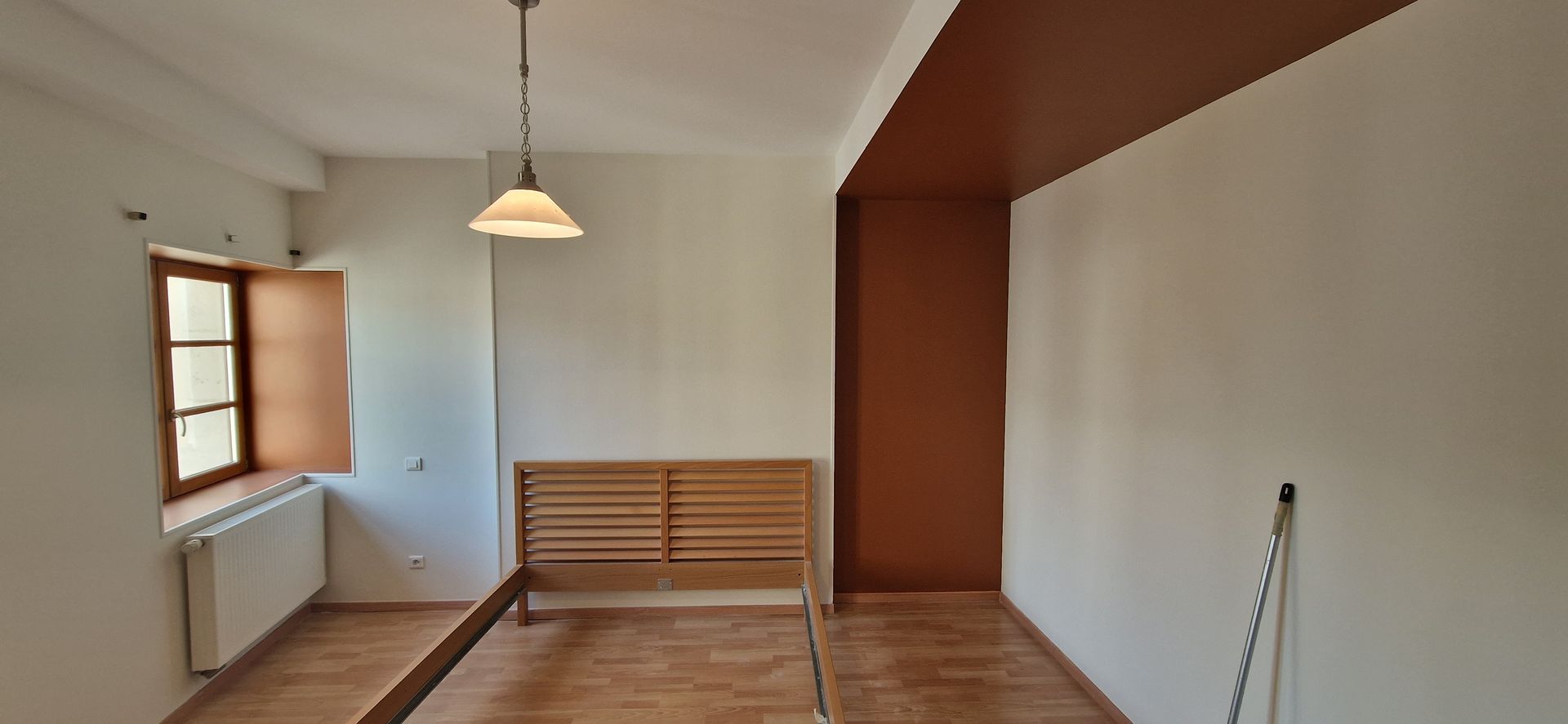 Chambre avec sommier et mur peint en deux couleurs