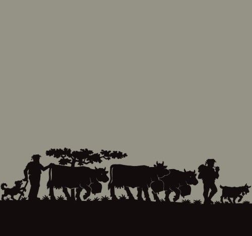 Die Silhouette eines Mannes, der neben einer Herde Kühe steht