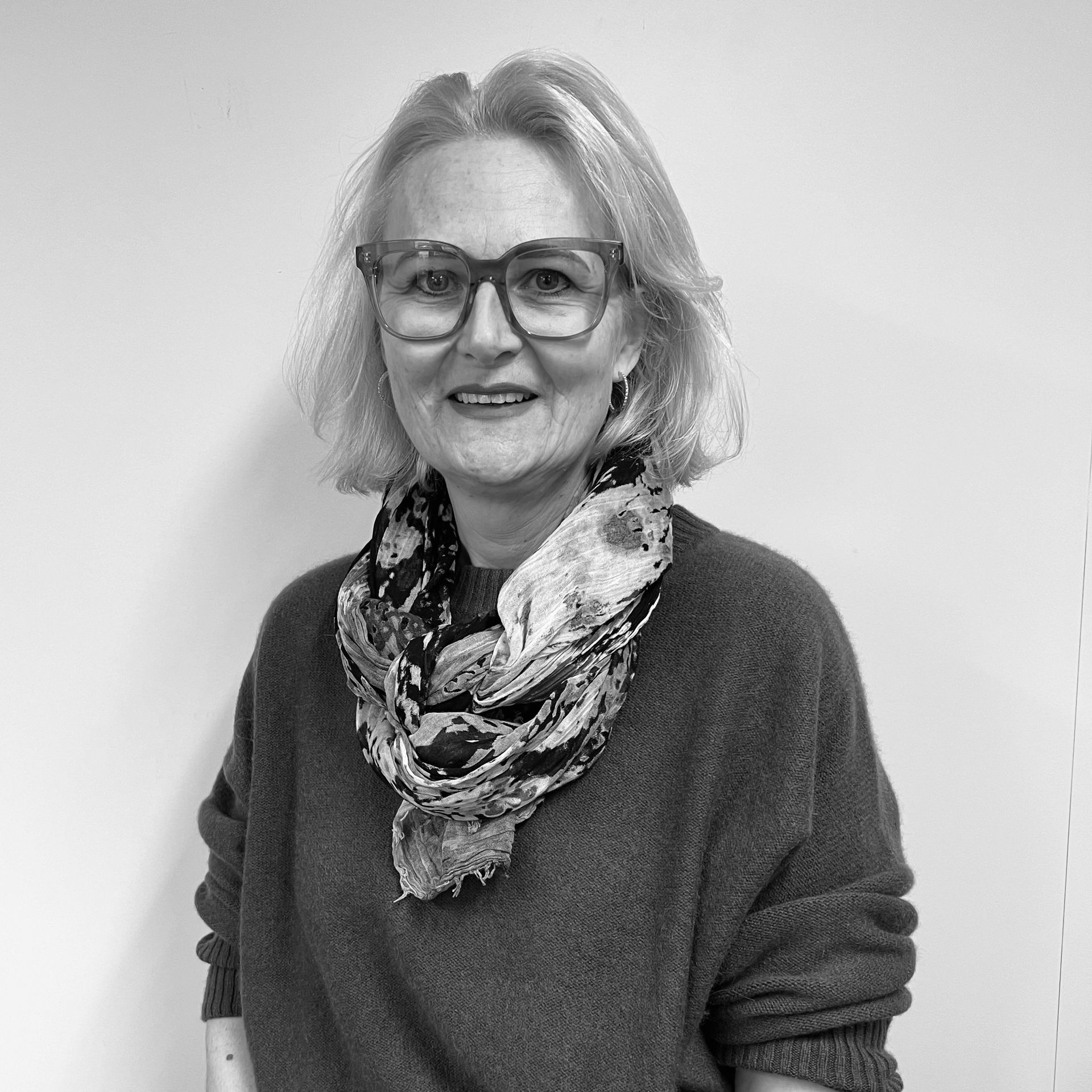 Ein Schwarzweißfoto einer Frau mit Brille und Kopftuch.